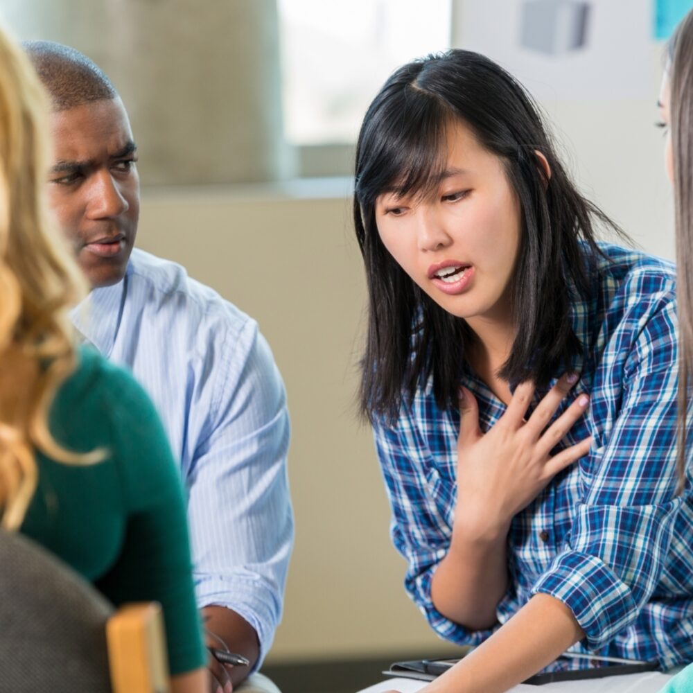 Young Asian woman talks in support group